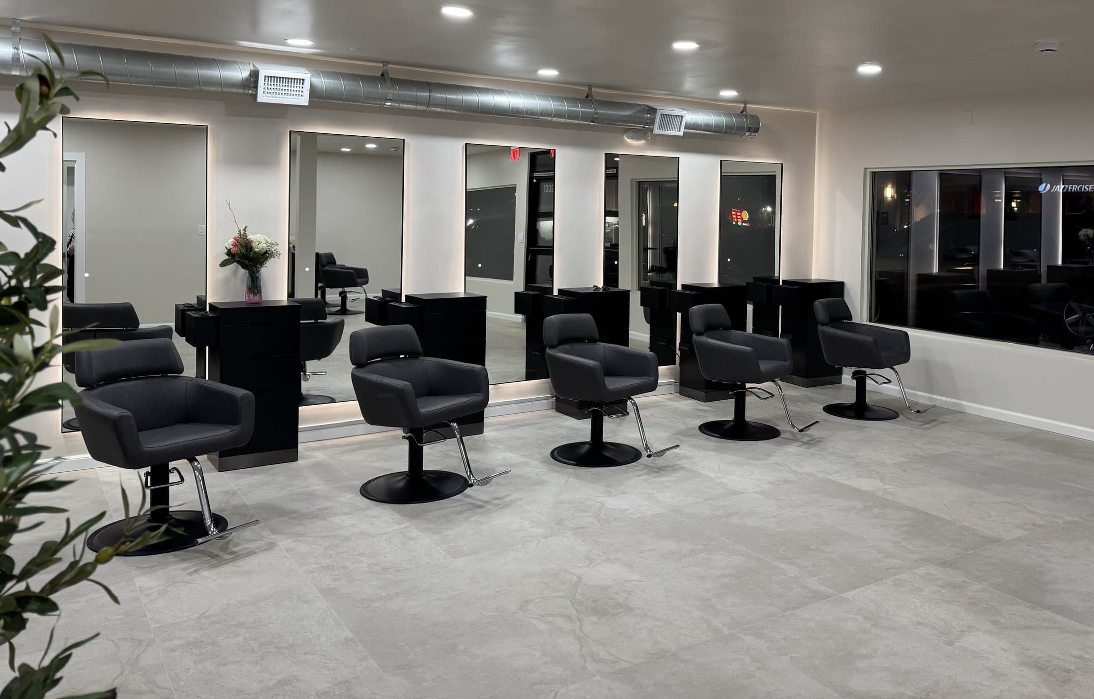 Styling stations with backlit mirrors inside The Cosmo Lab hair salon in Poway, California